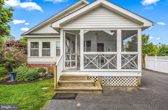 exterior space featuring a sunroom and fence