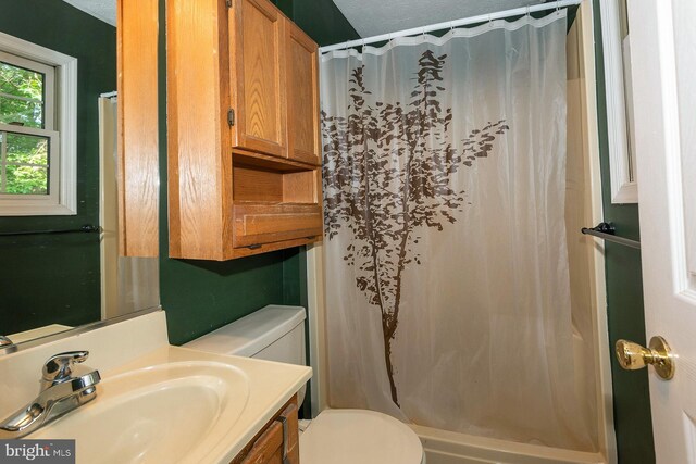 bathroom featuring toilet, a textured ceiling, vanity, and a shower with curtain