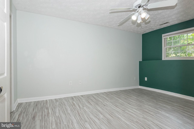 unfurnished room with a textured ceiling, ceiling fan, and light wood-type flooring