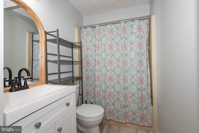 bathroom featuring toilet, a textured ceiling, vanity, and curtained shower