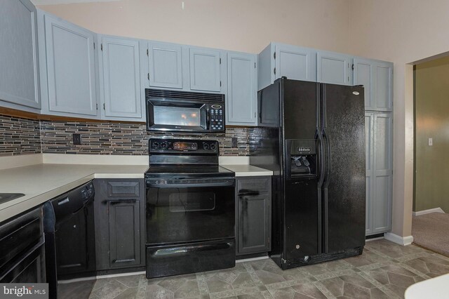 kitchen with tile patterned flooring, black appliances, and backsplash