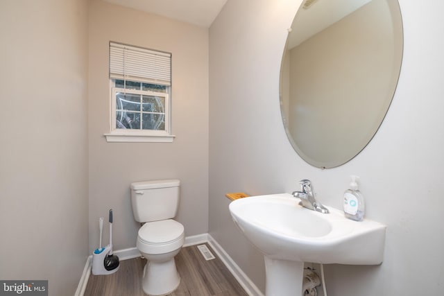 bathroom featuring hardwood / wood-style flooring and toilet