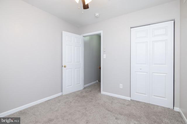 unfurnished bedroom featuring light carpet, a closet, and ceiling fan