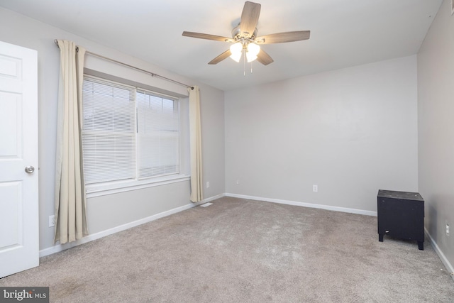 carpeted spare room featuring ceiling fan