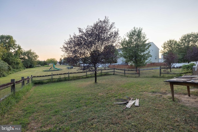 yard at dusk with a playground and a rural view