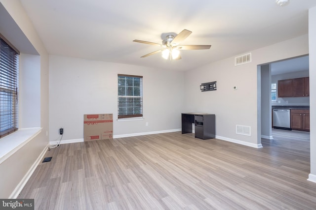 unfurnished living room featuring ceiling fan, light wood-type flooring, and plenty of natural light