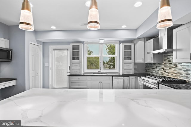 kitchen with appliances with stainless steel finishes, tasteful backsplash, light stone countertops, and hanging light fixtures