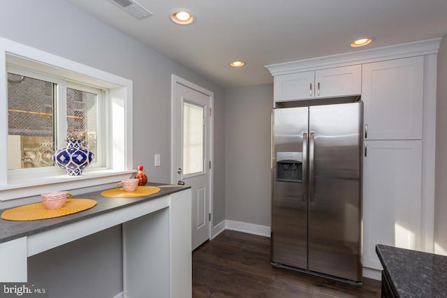 kitchen with dark countertops, recessed lighting, stainless steel refrigerator with ice dispenser, and white cabinets