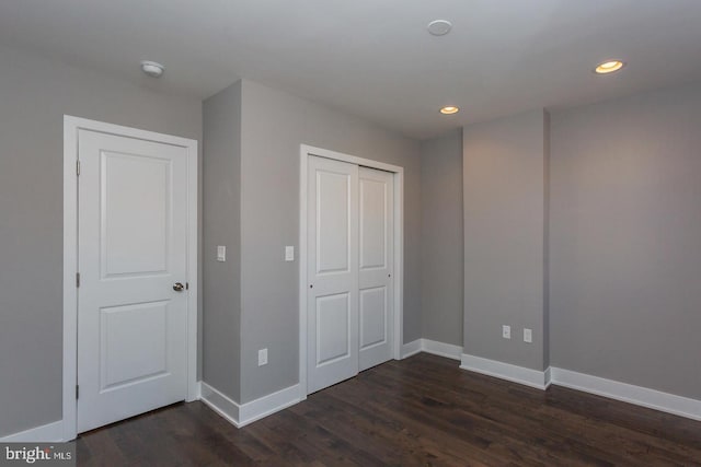 unfurnished bedroom with a closet and dark hardwood / wood-style floors