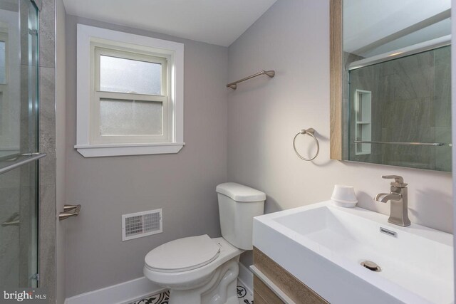 bathroom featuring toilet, vanity, and walk in shower