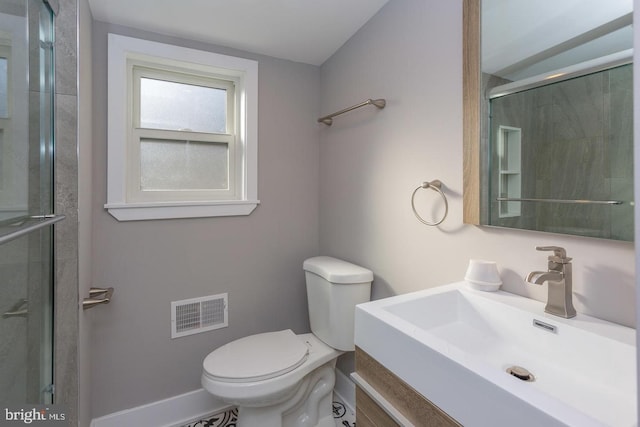 bathroom with toilet, vanity, visible vents, baseboards, and a stall shower