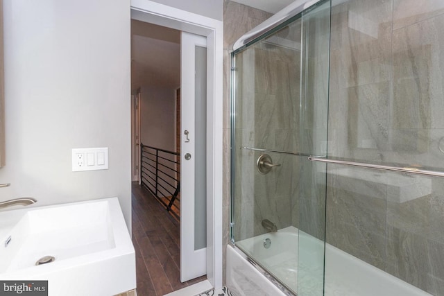 bathroom featuring combined bath / shower with glass door, wood-type flooring, and vanity