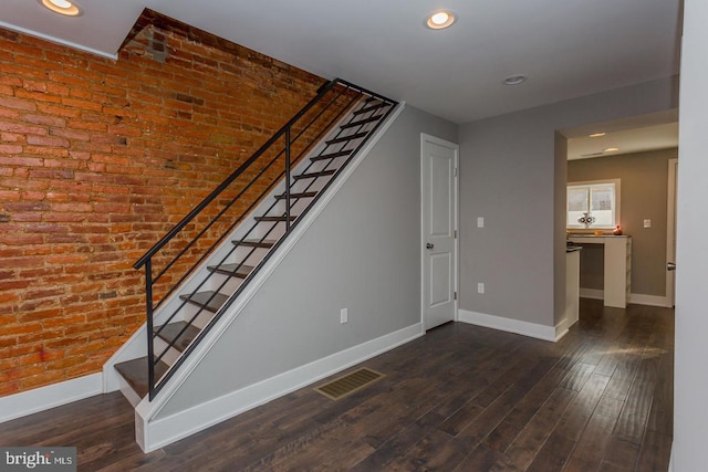 stairway featuring visible vents, baseboards, and wood finished floors