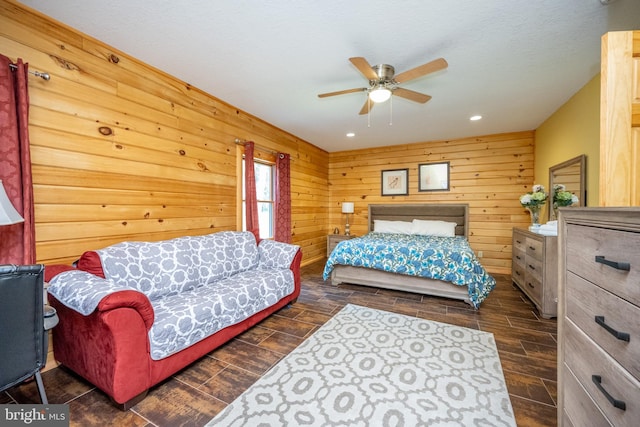 bedroom with wood finish floors, ceiling fan, and wooden walls