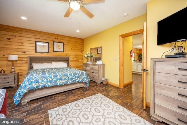 bedroom featuring dark wood-type flooring, ceiling fan, and wooden walls