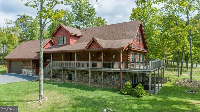 log home featuring a garage, a deck, and a front yard