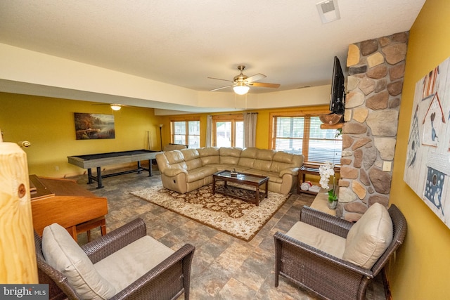 living room featuring a textured ceiling and ceiling fan