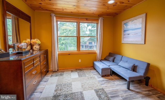 sitting room with light wood-type flooring, wood ceiling, and baseboards