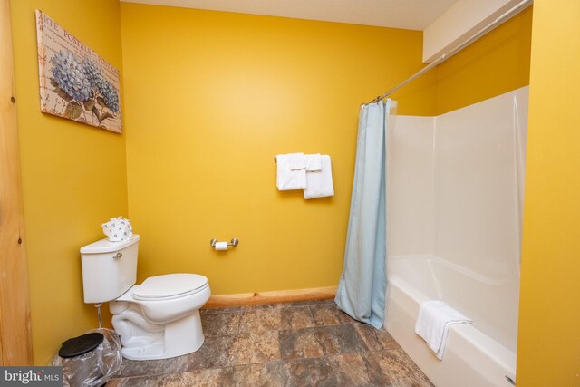 bathroom featuring toilet and shower / tub combo with curtain