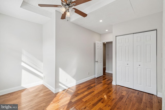 unfurnished bedroom featuring a closet, ceiling fan, and hardwood / wood-style flooring