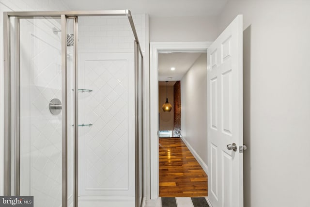 bathroom featuring a shower with door and hardwood / wood-style flooring