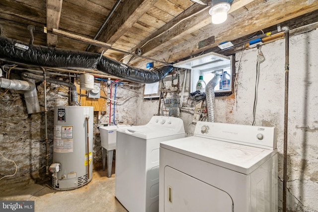 laundry area featuring washer and clothes dryer, gas water heater, and sink