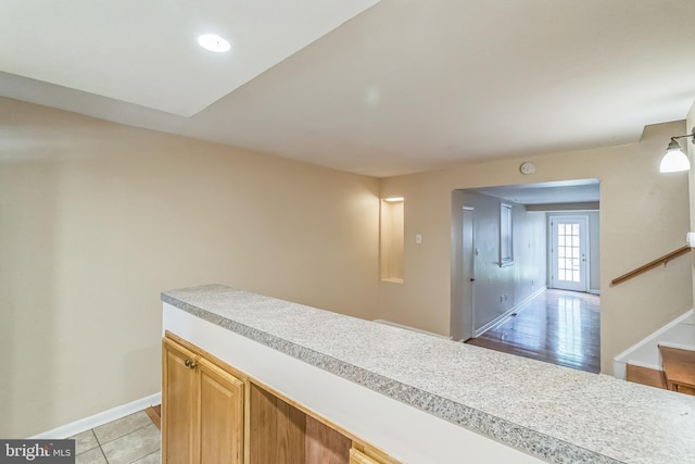 interior space featuring light tile patterned floors, stairs, and baseboards