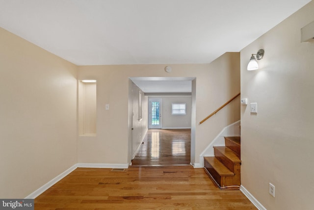 entrance foyer with stairs, baseboards, visible vents, and light wood-style floors