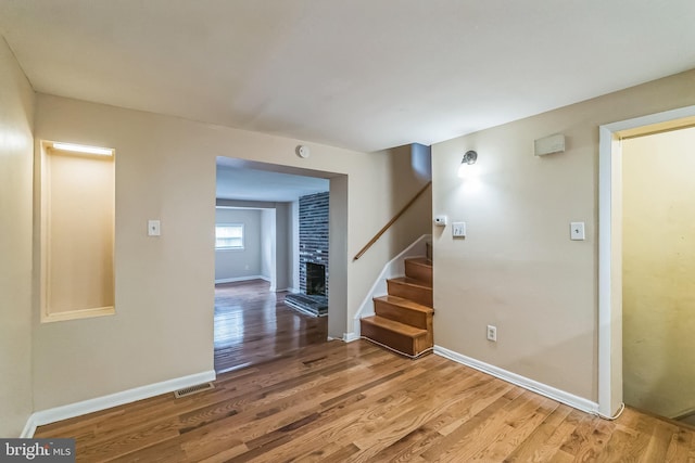 interior space with baseboards, visible vents, stairway, and wood finished floors