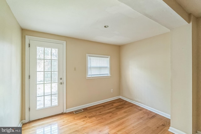 entryway with light wood finished floors, a wealth of natural light, and visible vents