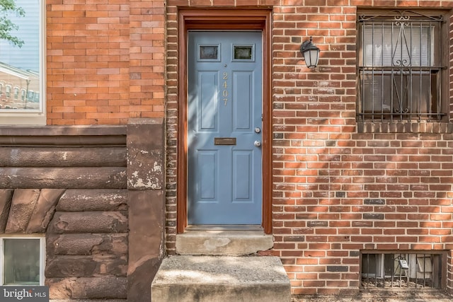 view of exterior entry with brick siding