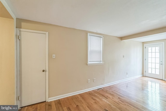 unfurnished room with light wood-type flooring, baseboards, and visible vents