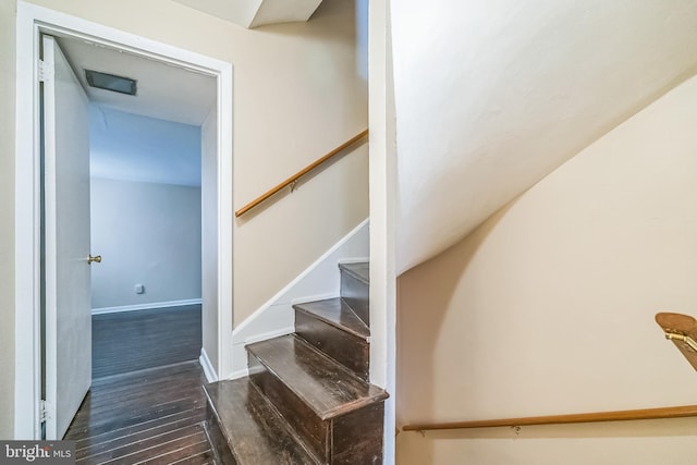 staircase with wood finished floors and baseboards