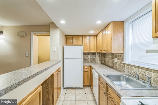 kitchen with light countertops, backsplash, light tile patterned flooring, a sink, and white appliances