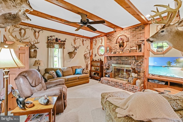 living room with a fireplace, beamed ceiling, ceiling fan, carpet, and brick wall