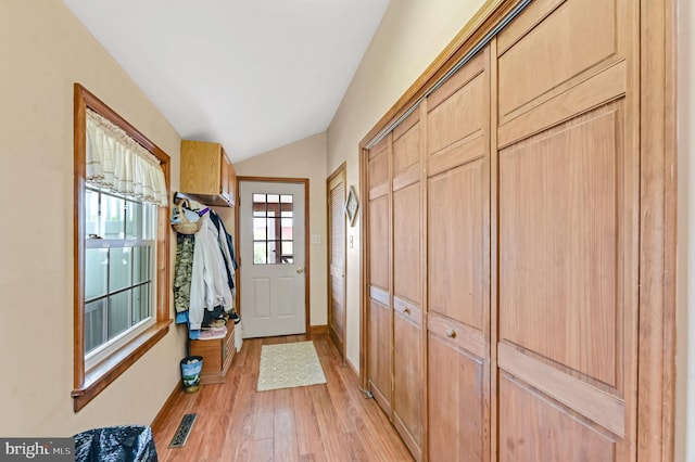 doorway with vaulted ceiling and light hardwood / wood-style floors