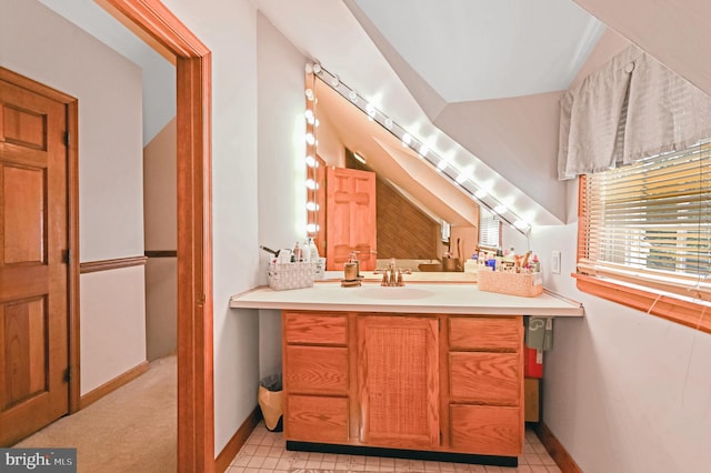 bathroom featuring tile patterned floors, vaulted ceiling, and vanity