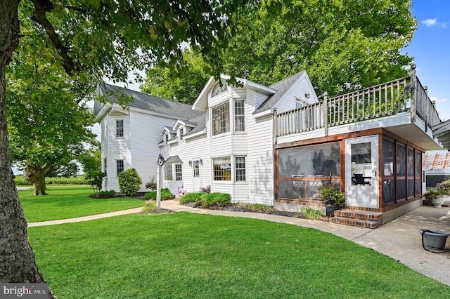 exterior space with a sunroom and a lawn