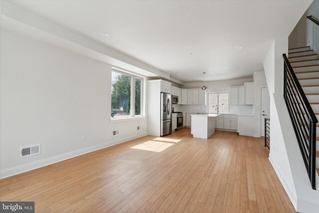 unfurnished living room with sink and light wood-type flooring