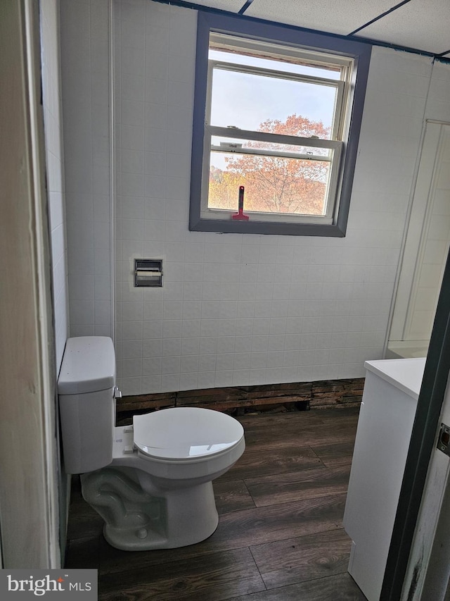 bathroom with tile walls, a textured ceiling, hardwood / wood-style flooring, and toilet