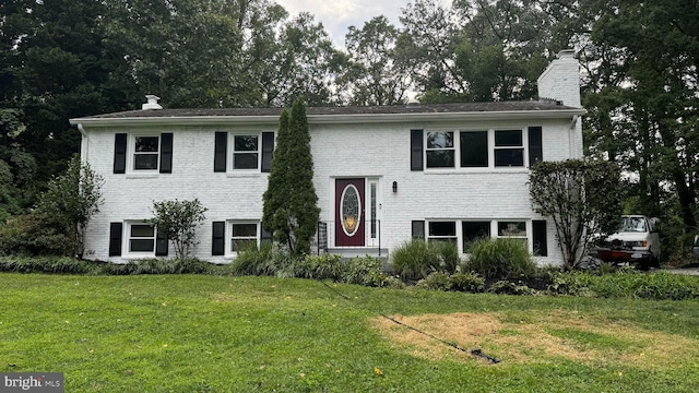 raised ranch with a front yard