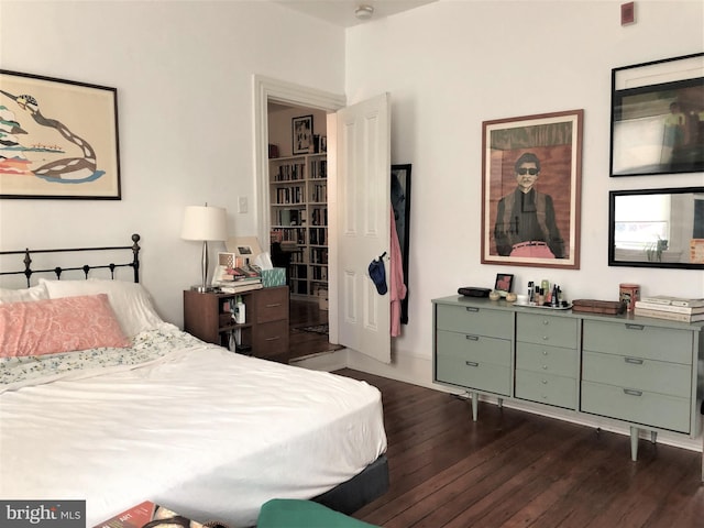 bedroom with dark hardwood / wood-style flooring