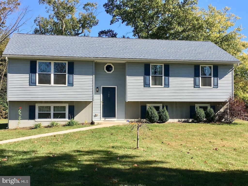 raised ranch featuring a front lawn