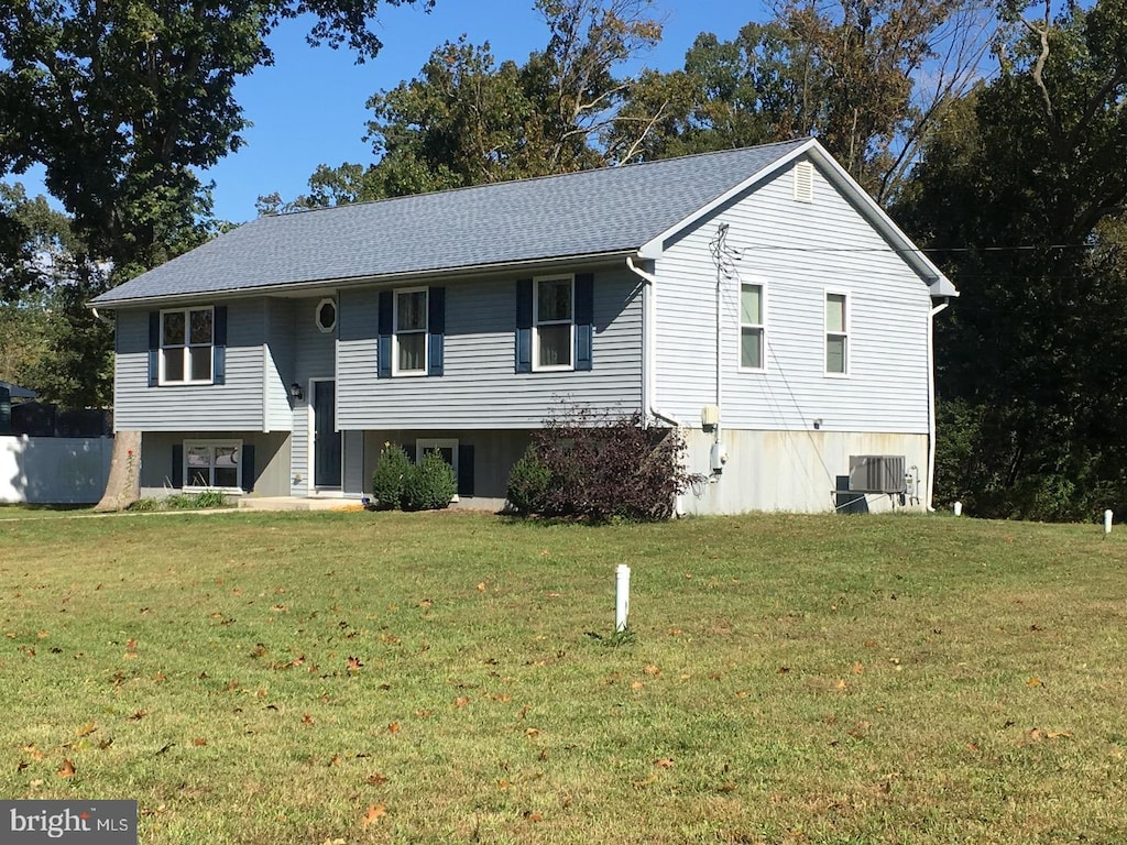 split foyer home featuring a front lawn and central air condition unit