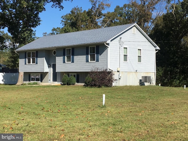 split foyer home featuring a front lawn and central air condition unit