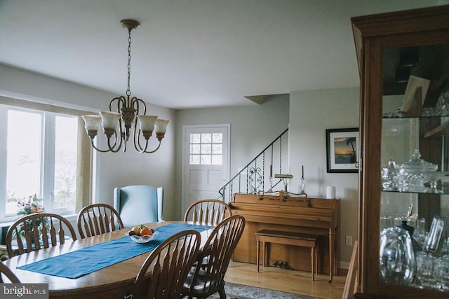 dining room with hardwood / wood-style floors and a notable chandelier