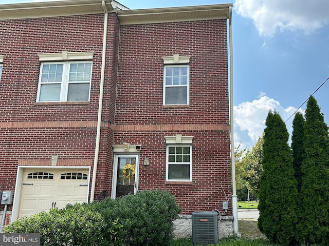 multi unit property featuring central air condition unit and a garage