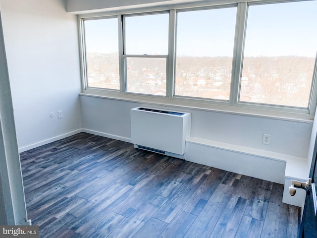 spare room featuring radiator heating unit and dark hardwood / wood-style floors