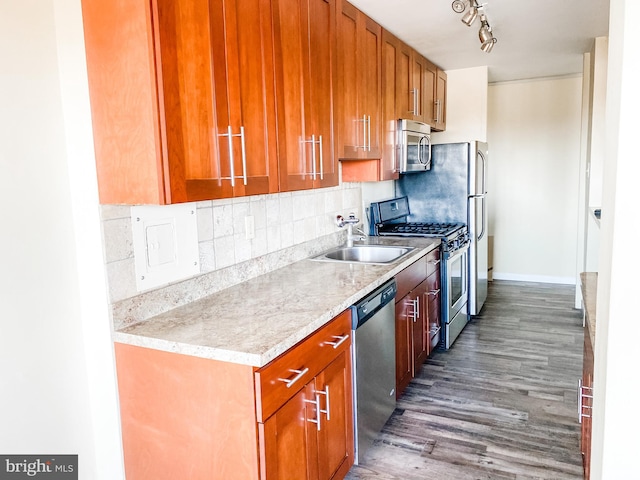 kitchen featuring tasteful backsplash, light stone counters, dark wood-type flooring, sink, and stainless steel appliances