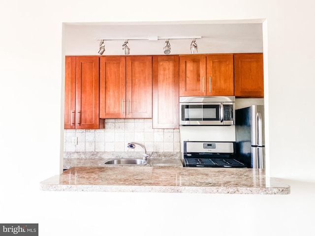 kitchen with sink, decorative backsplash, and stainless steel appliances